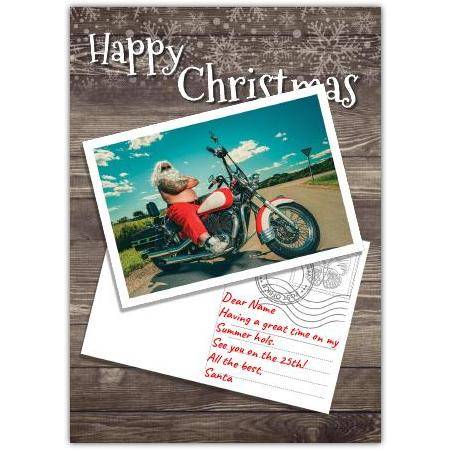 Happy Christmas Card with Santa Riding Motorbike on Wood Background